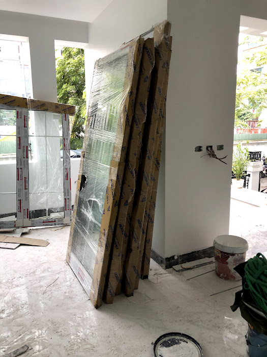 Cửa nhôm kính mới bọc carton dựng trong nhà đang thi công sửa chữa